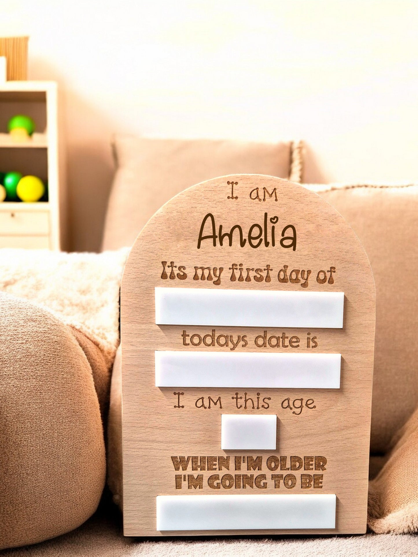 Personalised first day memory board with engraved name and date markers, displayed on a soft fabric surface.