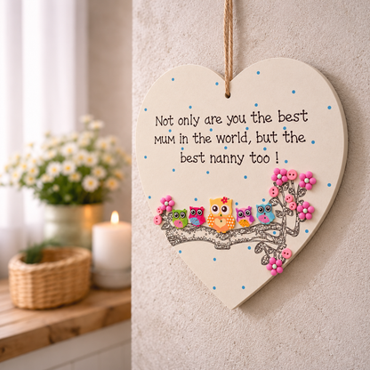 Best Mum and Nanny owl heart plaque hanging on a neutral wall with flowers in the background