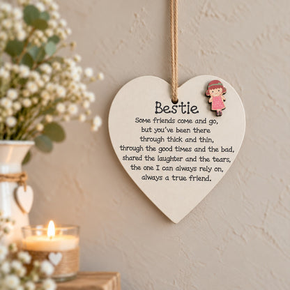 Bestie wooden heart plaque with friendship quote and raised girl embellishment hanging on a light wall