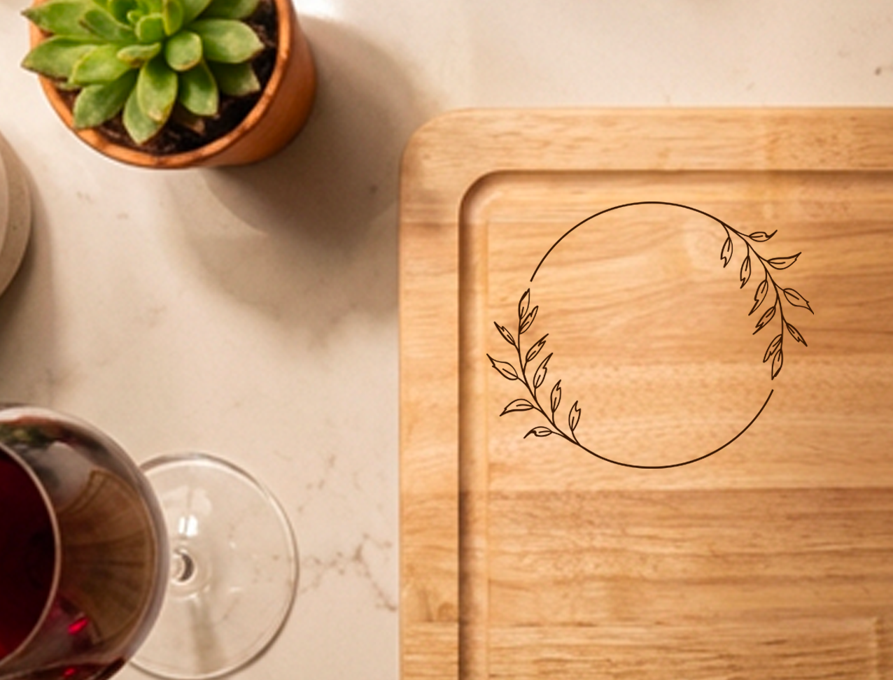 Close-up of personalised wooden chopping and serving board showing engraving wreath layout area