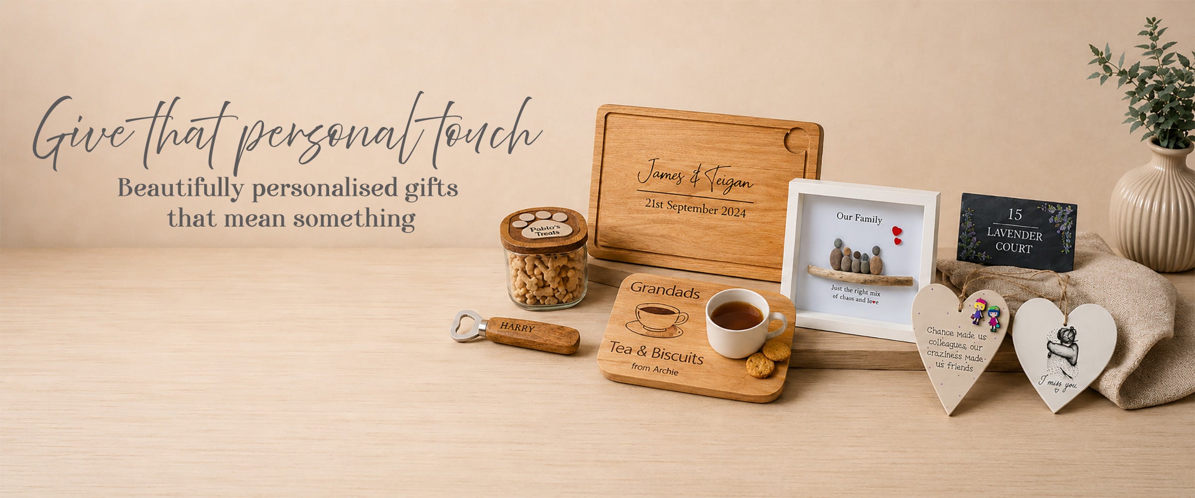 Personalised gifts including a cutting board, photo frame, and heart-shaped signs on a wooden surface.