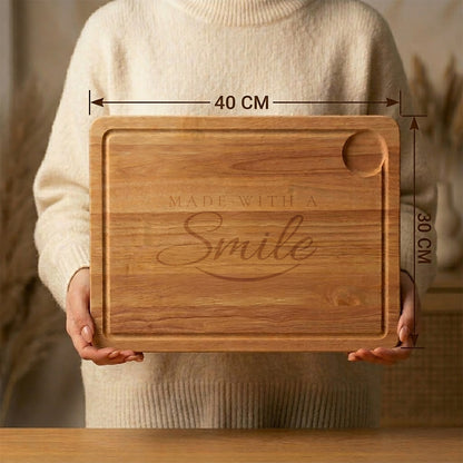 Wooden cutting board with 'Made with a Smile' engraving held by a person, showing dimensions.