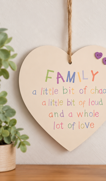 Family wooden heart plaque with colourful wording and purple heart embellishments displayed on a light neutral wall