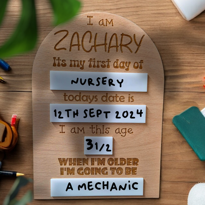 Close-up of engraved name and details on wooden memory board for school or nursery milestones.