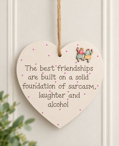 Friendship wooden heart plaque with sarcasm laughter and alcohol quote displayed on a light neutral wall