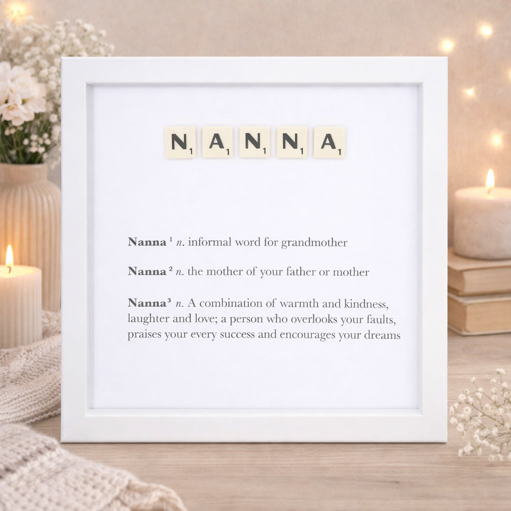 Framed print with the word 'NANNA' spelled out using scrabble tiles, surrounded by candles and flowers