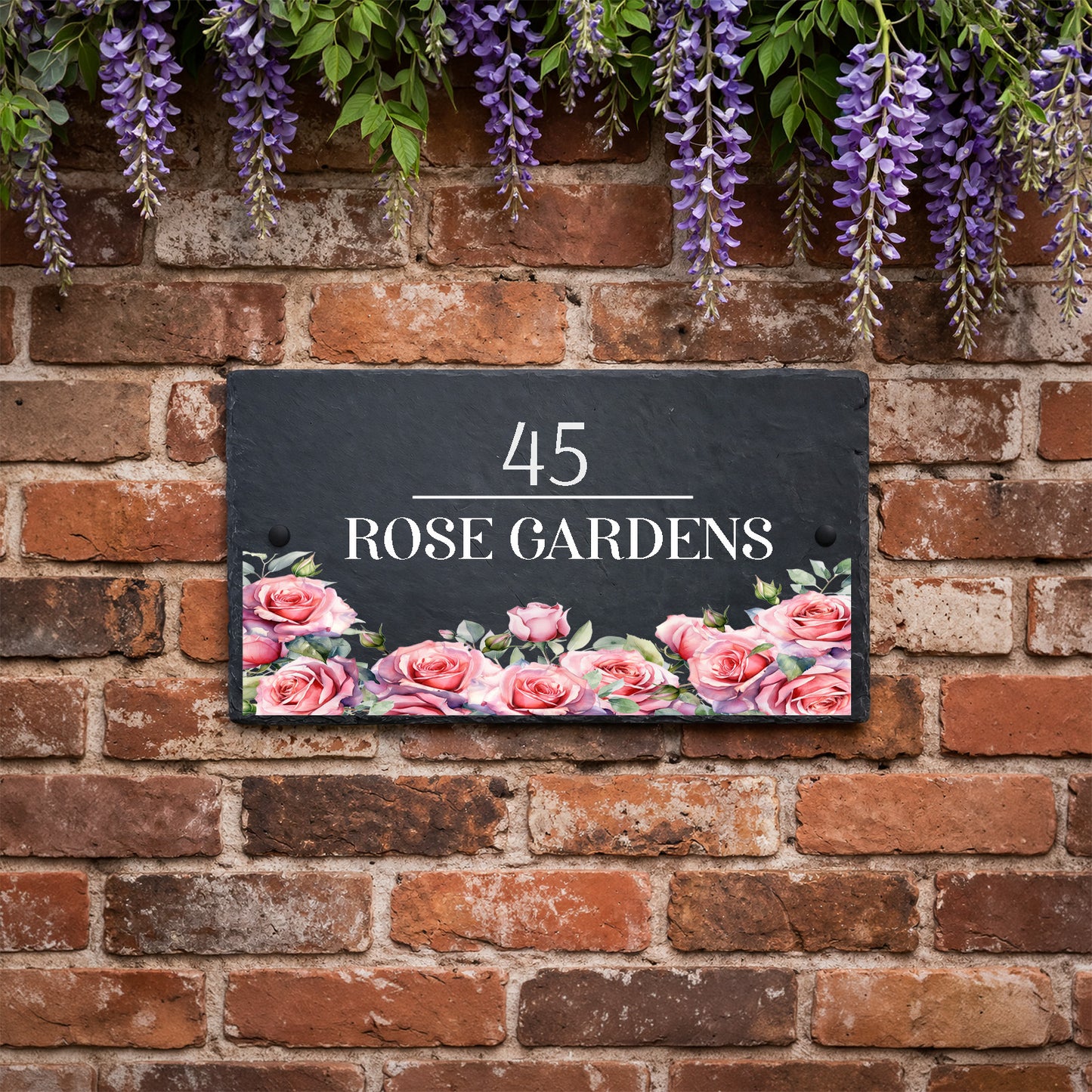 Personalised slate house sign with rose design along the bottom, house number and house name mounted on an exterior wall