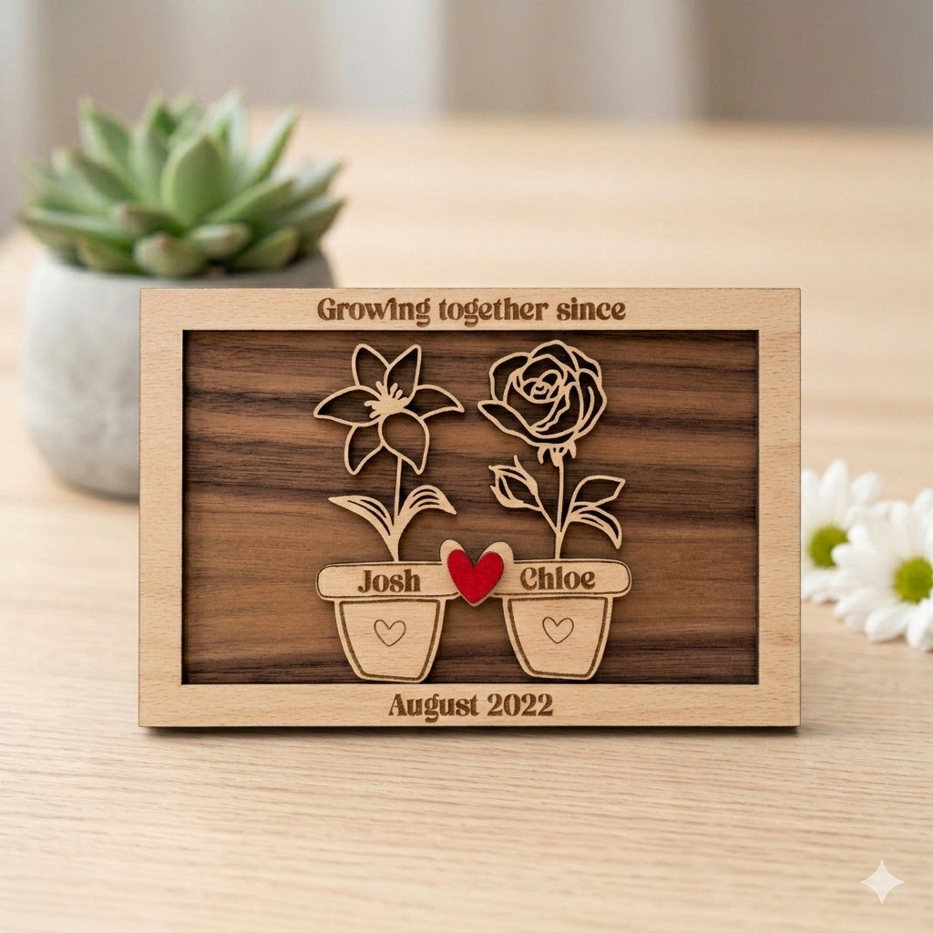 Personalised Wooden frame with floral designs and engraved names on a wooden surface. 