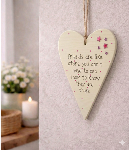 Heart-shaped wooden plaque with a quote friends are like stars with sparkly stars on a neutral beige background