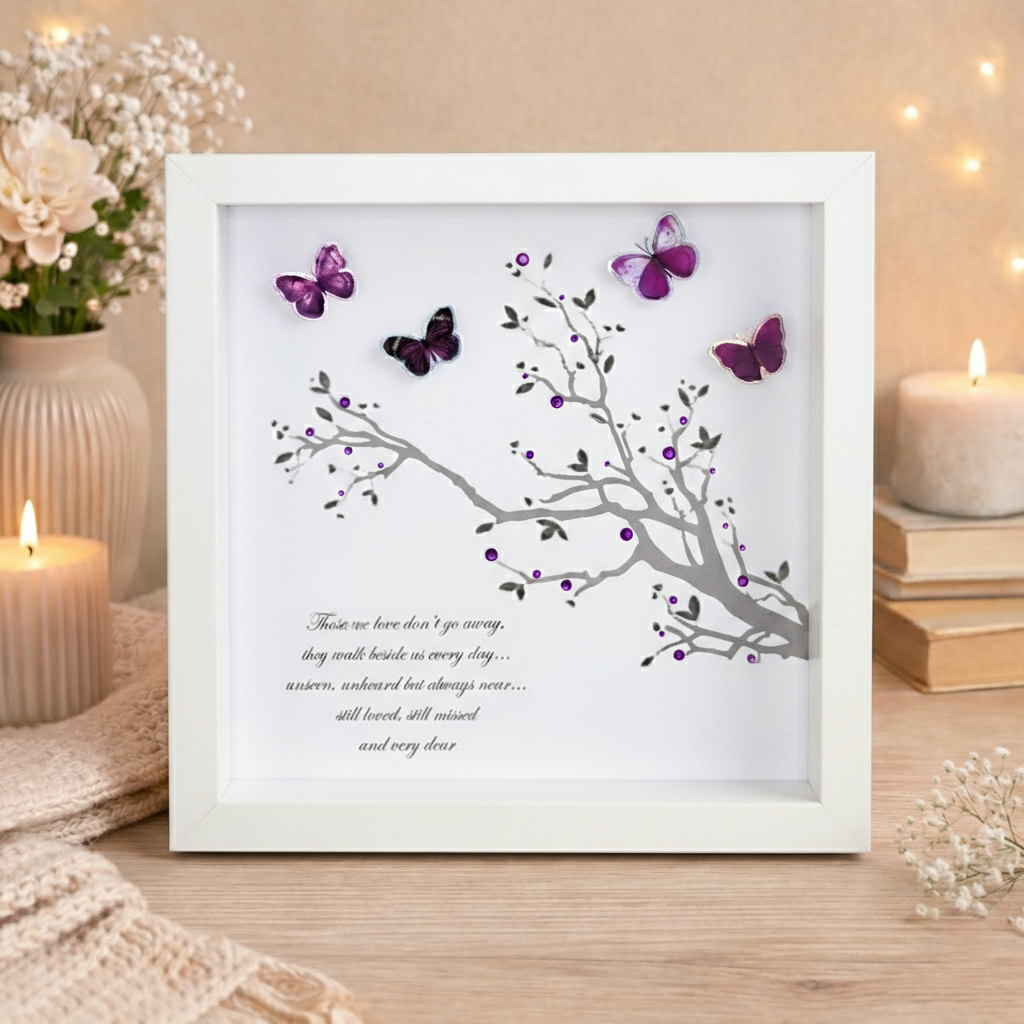 Those We Love Don’t Go Away memorial poem frame with 3D butterflies in white box frame displayed on wooden surface with candles and flowers.
