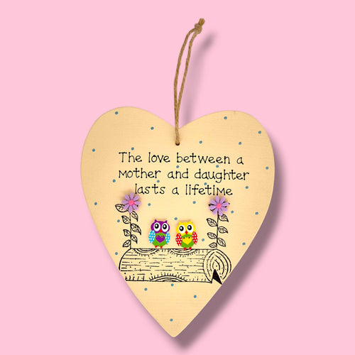 a wooden hanging plaque with the verse the love between a mother and daughter lasts a lifetime